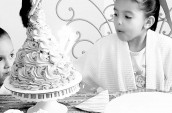girl blowing out candles on a cake