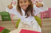 girl sitting on chair showing two thumbs up