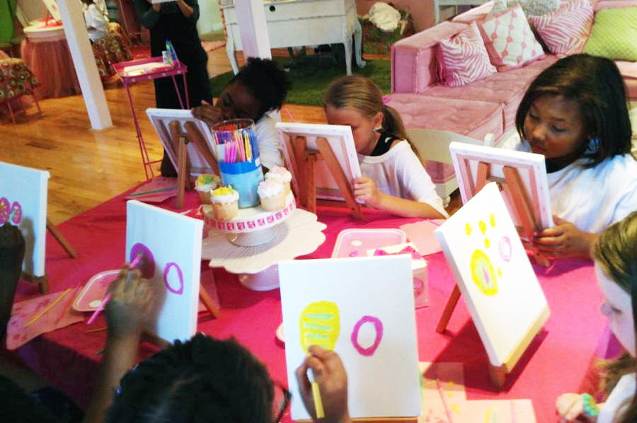 kids busy painting on a small canvasses