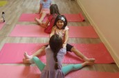 girls sitting facing each other on yoga mats