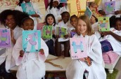 girls holding up their canvas paintings