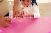 girl sitting at table playing with ultimate slime