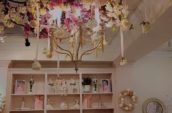 a room with a table and chairs on a bare wooden floor under a chandelier