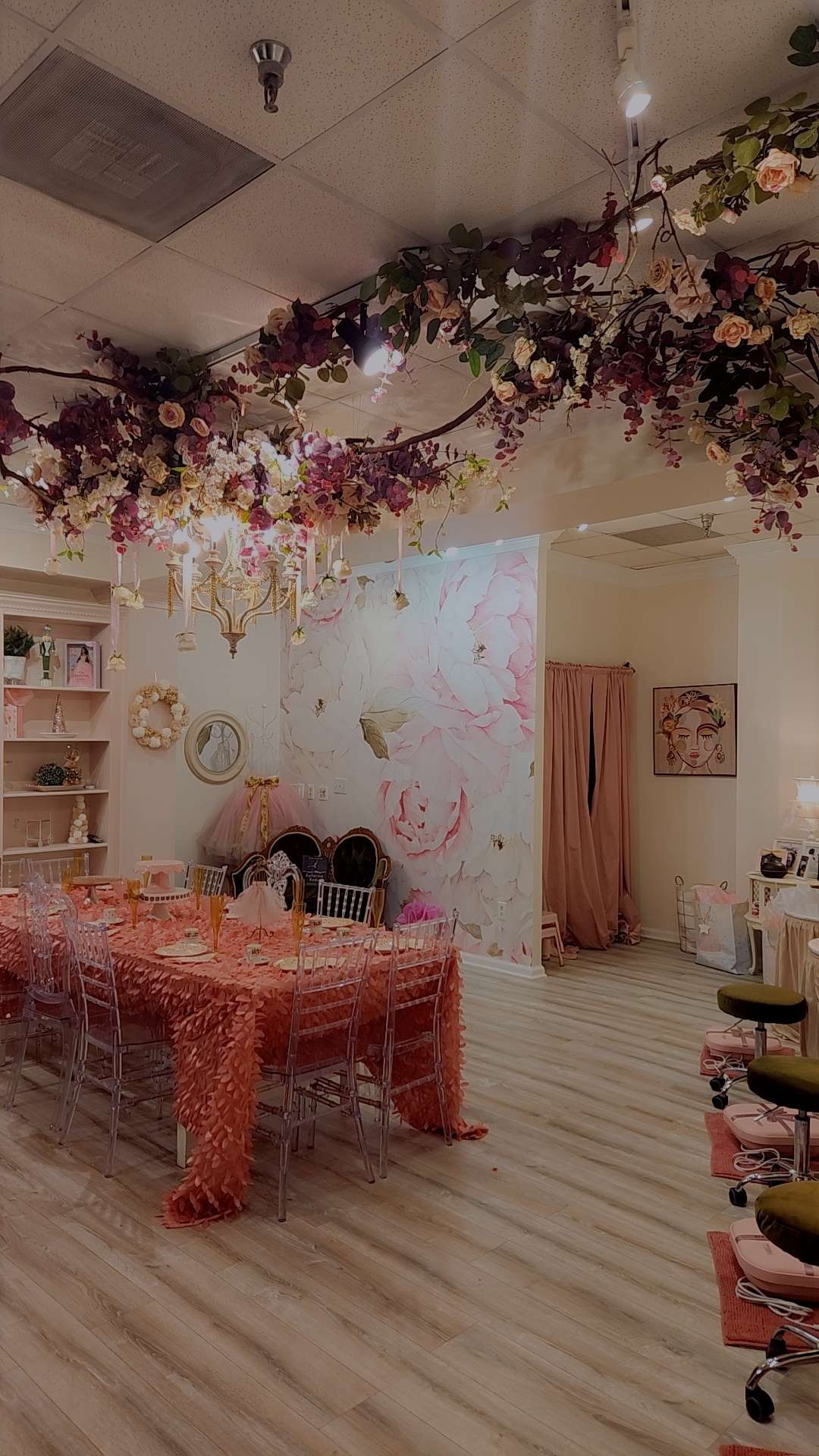 a room with a table and chairs on a bare wooden floor under a chandelier